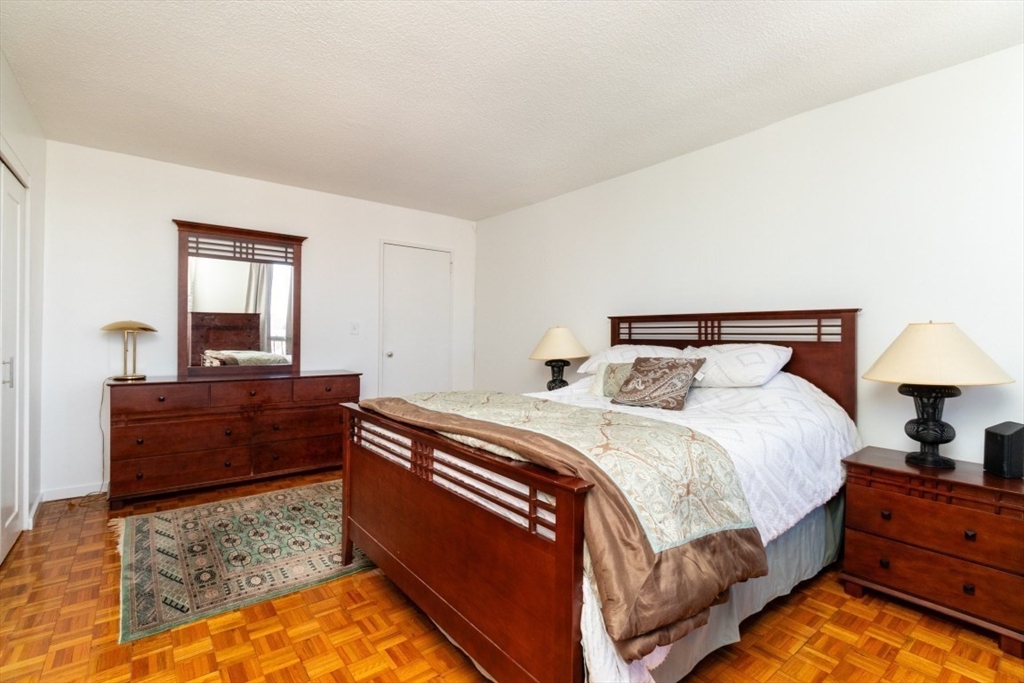 33 Pond Avenue, Unit 1106 Brookline, MA 02445 - Photo 19 of 32 a bed room with a bed and a lamp
