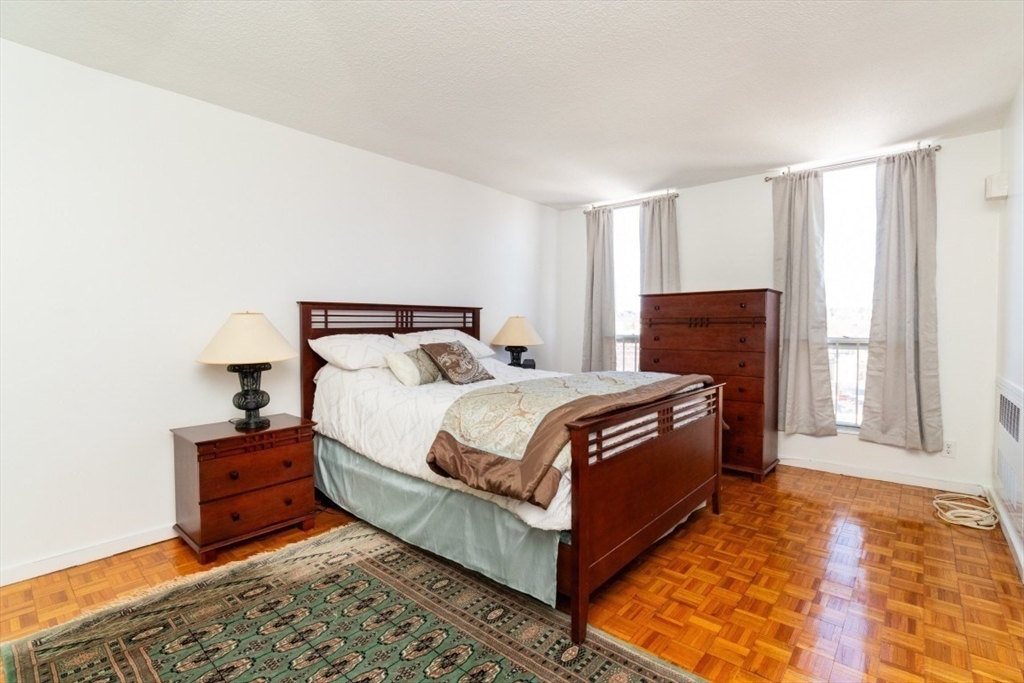 33 Pond Avenue, Unit 1106 Brookline, MA 02445 - Photo 21 of 32 a bedroom with a bed and wooden floor