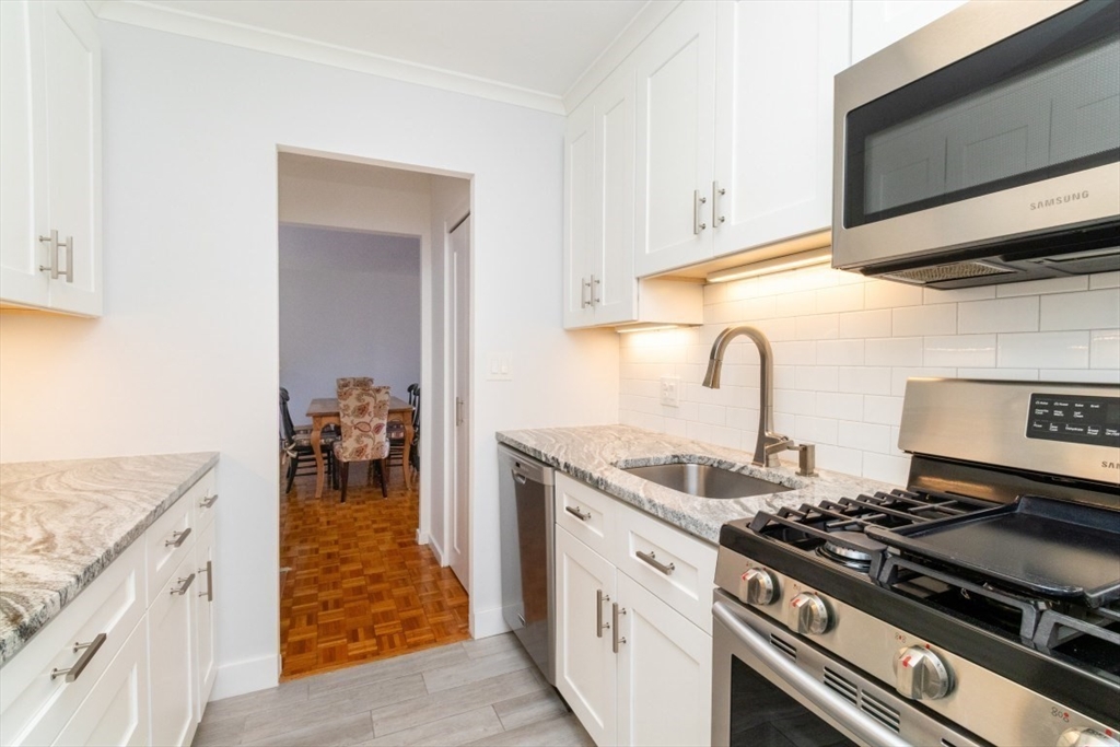 33 Pond Avenue, Unit 1106 Brookline, MA 02445 - Photo 6 of 32 a kitchen with granite countertop a stove and a sink