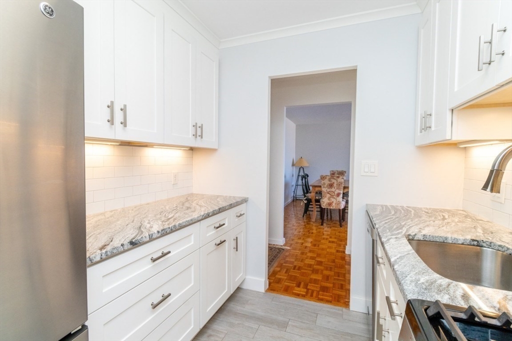 33 Pond Avenue, Unit 1106 Brookline, MA 02445 - Photo 7 of 32 a kitchen with granite countertop a sink and a stove