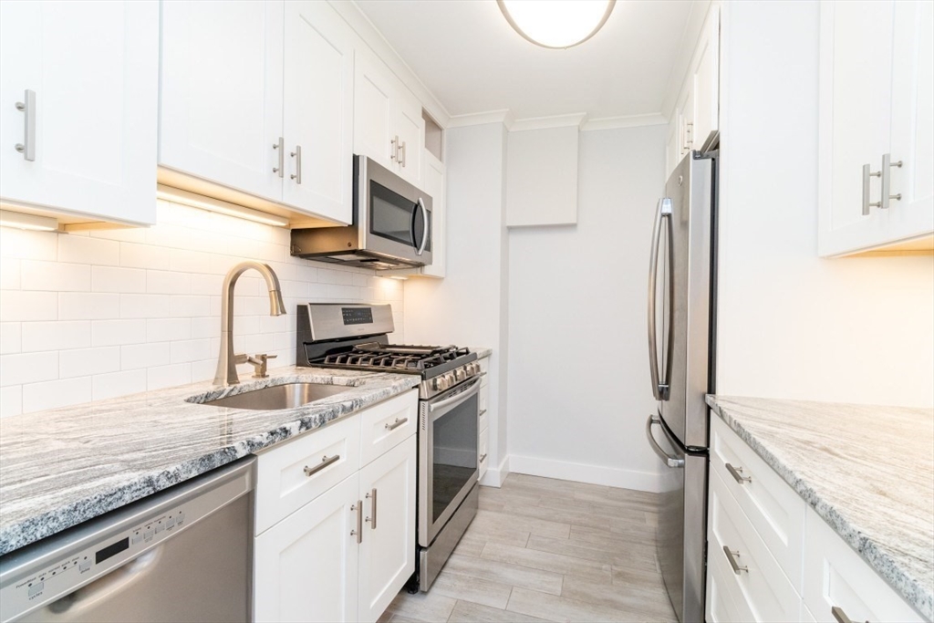 33 Pond Avenue, Unit 1106 Brookline, MA 02445 - Photo 8 of 32 a kitchen with stainless steel appliances granite countertop a stove and a sink