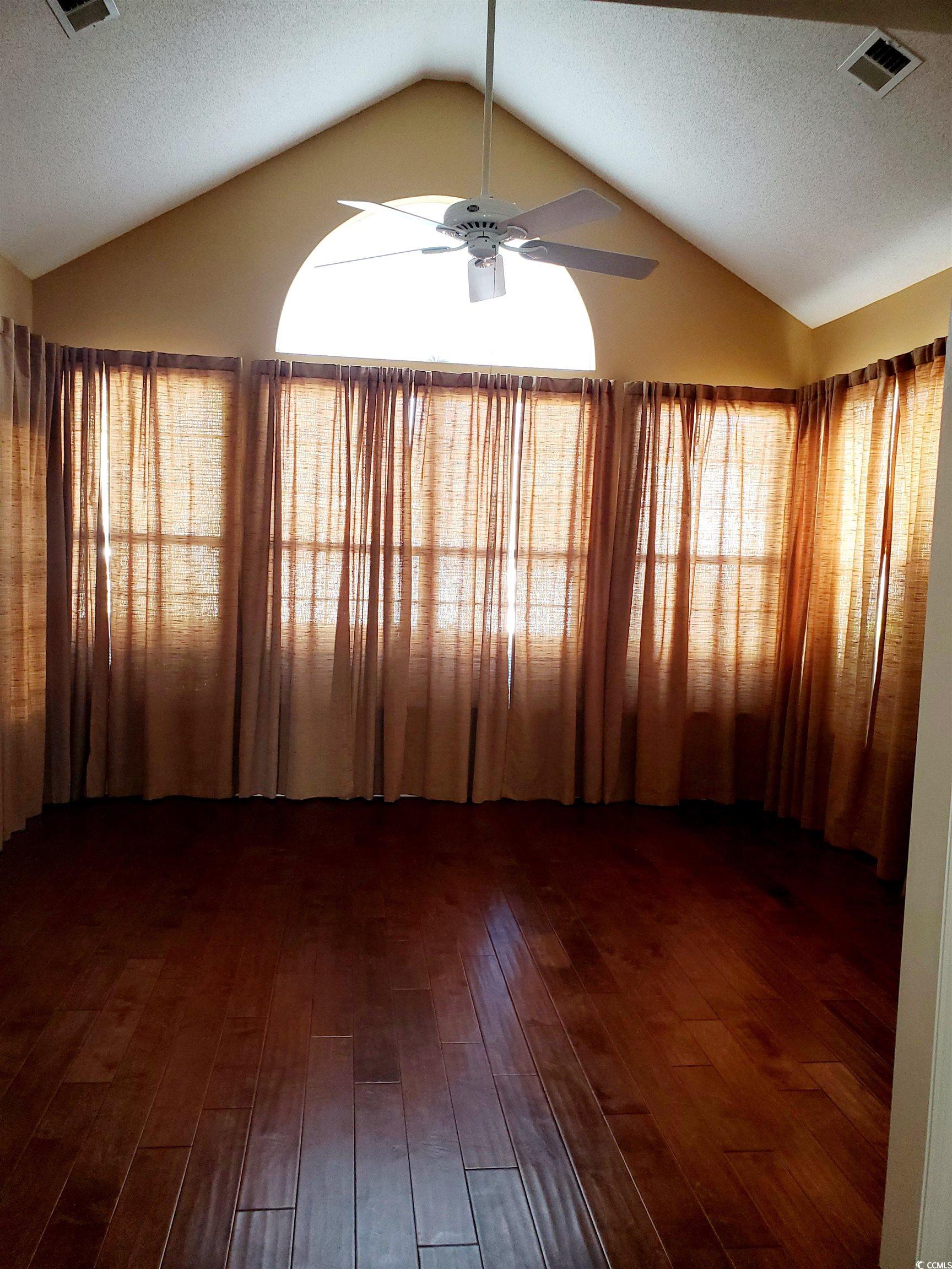 219 Spring Lake Drive Myrtle Beach, SC 29579 - Photo 18 of 20 Unfurnished room with lofted ceiling, a textured ceiling, a ceiling fan, and dark wood finished floors