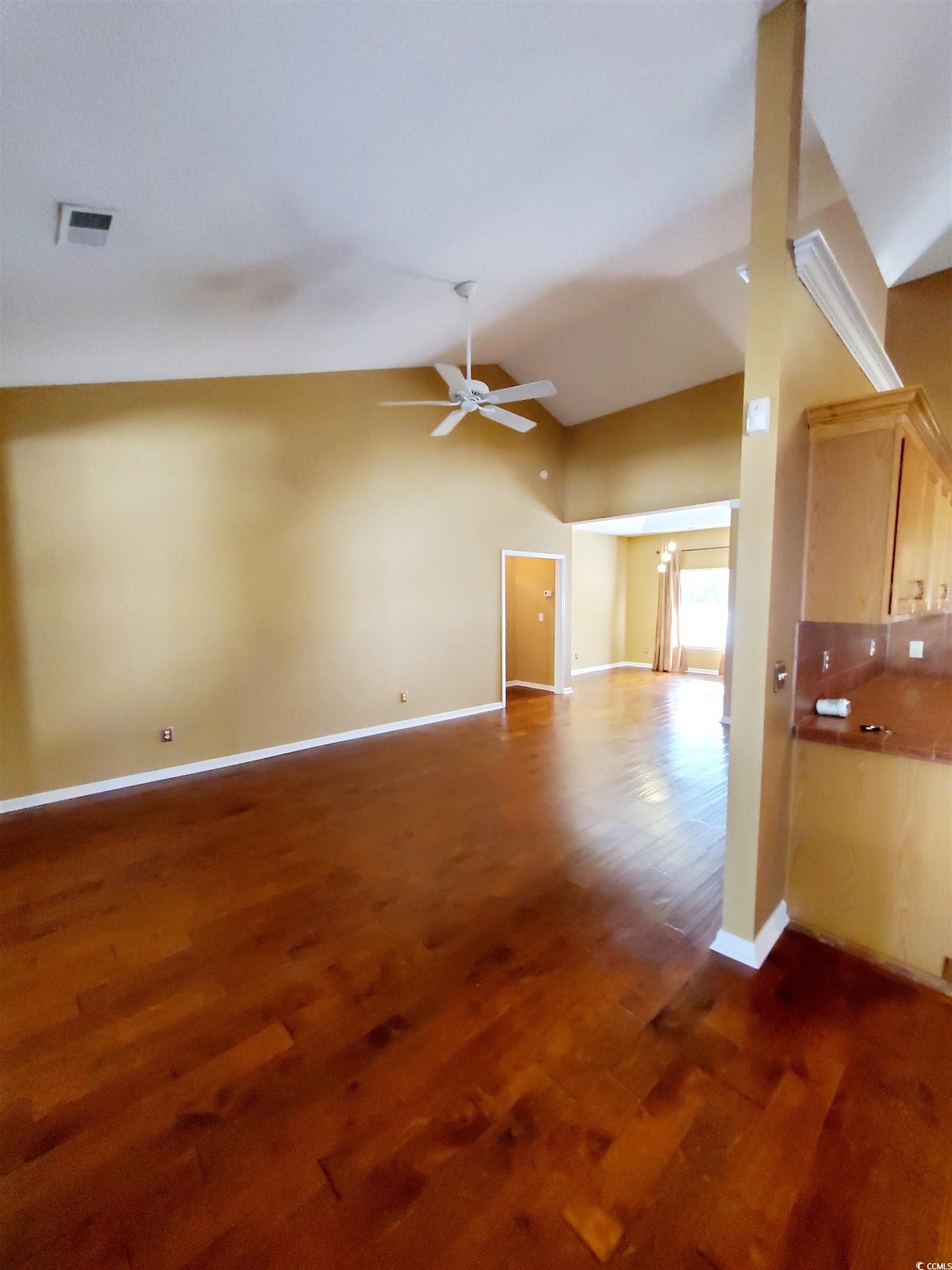 219 Spring Lake Drive Myrtle Beach, SC 29579 - Photo 19 of 20 Unfurnished living room featuring dark wood-style floors, lofted ceiling, and a ceiling fan