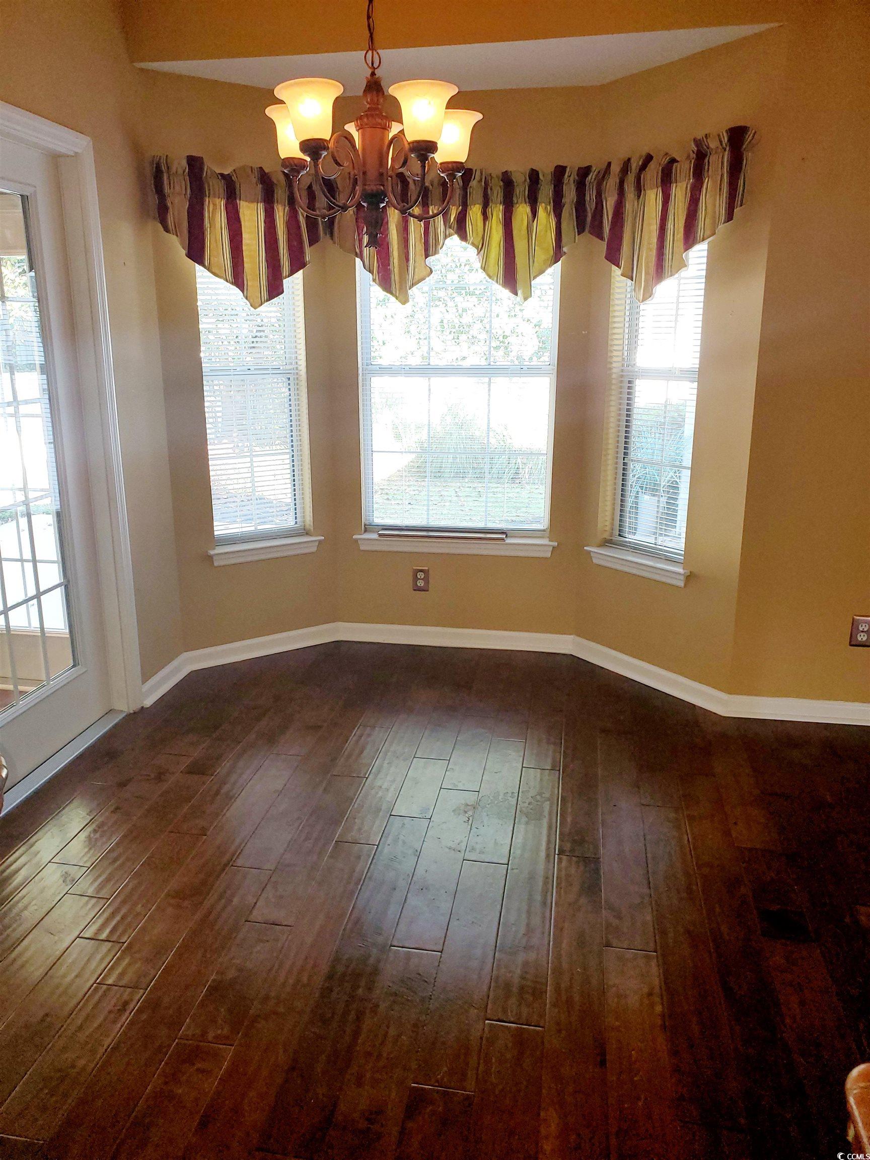 219 Spring Lake Drive Myrtle Beach, SC 29579 - Photo 20 of 20 Unfurnished dining area with a chandelier and dark wood-style floors