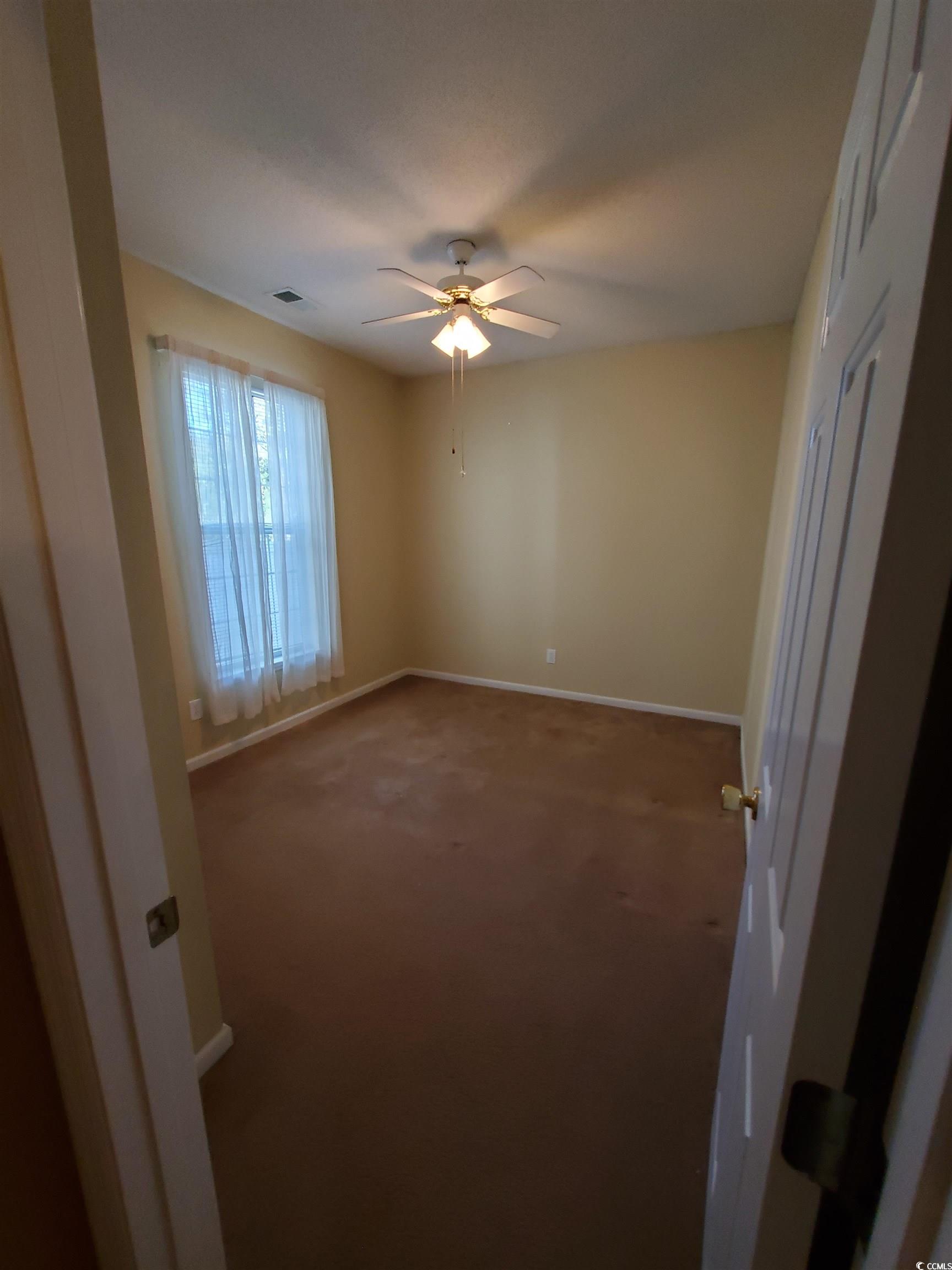 219 Spring Lake Drive Myrtle Beach, SC 29579 - Photo 5 of 20 Empty room with carpet and a ceiling fan