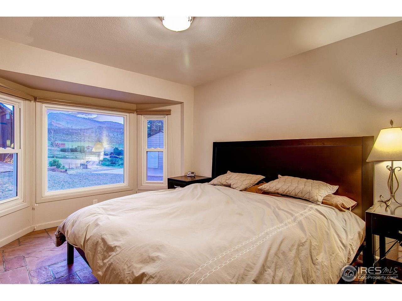 427 Red Gulch Road Lyons, CO 80540 - Photo 20 of 25 a bedroom with a bed and a painting on the wall