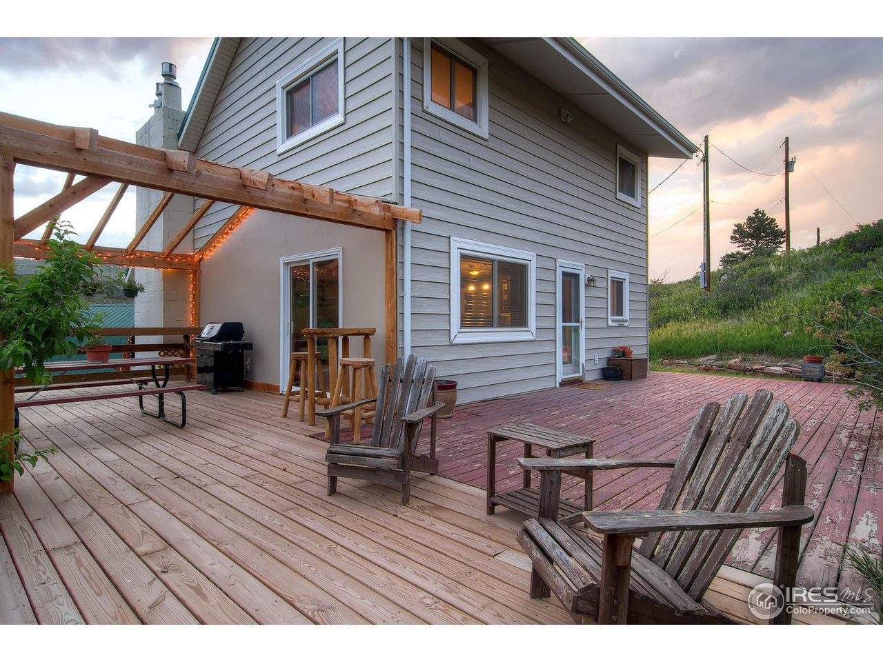 427 Red Gulch Road Lyons, CO 80540 - Photo 21 of 25 a view of a patio with table and chairs with wooden floor and fence