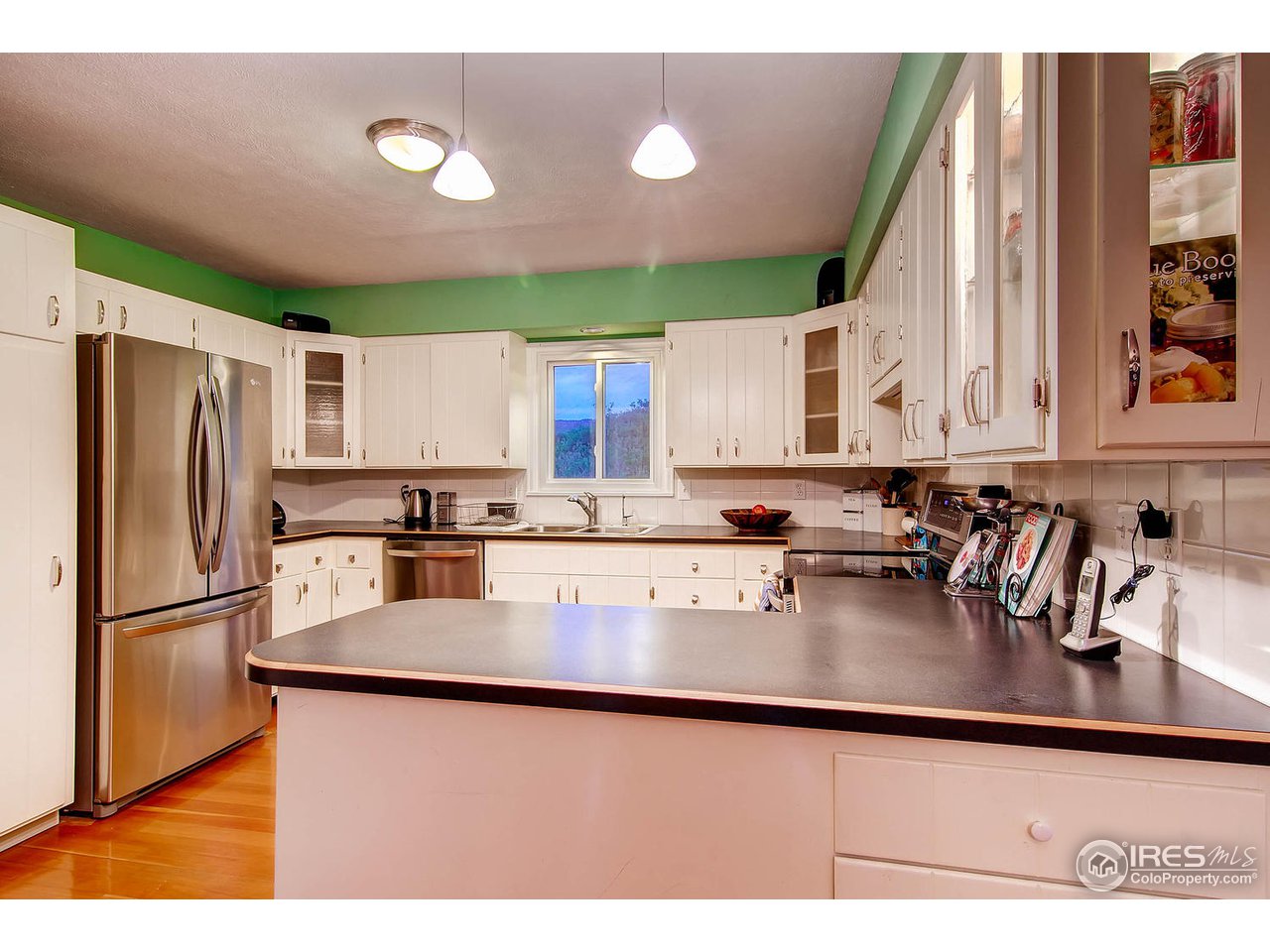 427 Red Gulch Road Lyons, CO 80540 - Photo 9 of 25 a kitchen with stainless steel appliances granite countertop a refrigerator a sink dishwasher a stove and white cabinets with wooden floor
