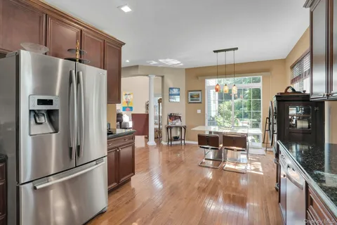 a kitchen with stainless steel appliances granite countertop a refrigerator a stove top oven a sink and dishwasher