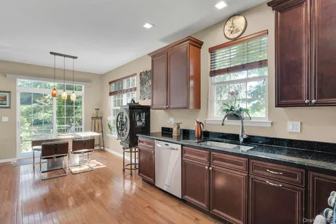 a kitchen with kitchen island wooden floor and stainless steel appliances