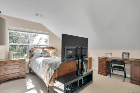 a bedroom with a bed a chandelier and a window