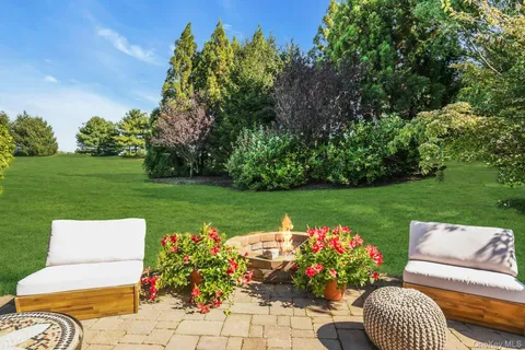 a view of a patio with table and chairs potted plants with lake view