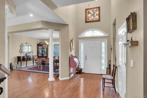 a view of a hallway with wooden floor and a living room