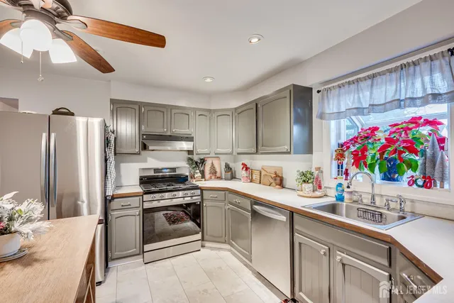 a kitchen with granite countertop a sink stainless steel appliances and cabinets