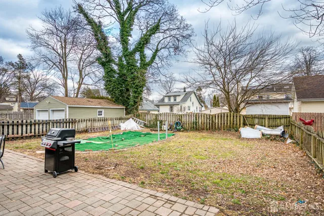 a view of a house with a yard and trees