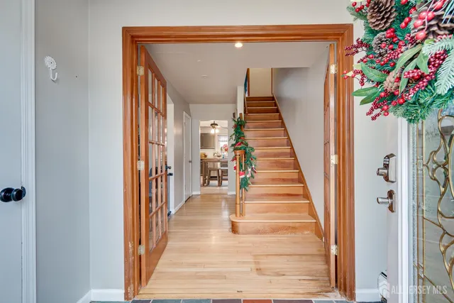 a view of a hallway with wooden floor and stairs