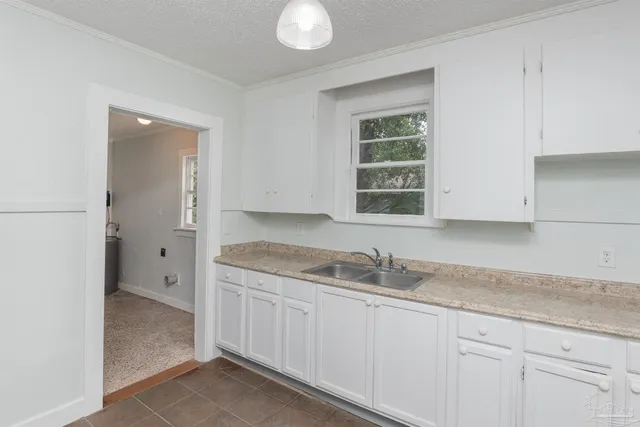a kitchen with granite countertop white cabinets and a sink