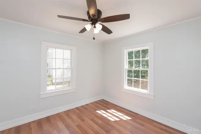 an empty room with windows and fan