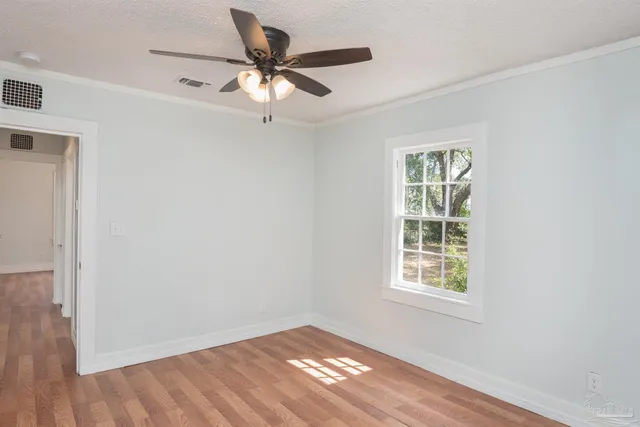 a view of a room with wooden floor and a ceiling fan