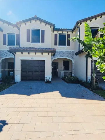 a front view of a house with a yard and a garage