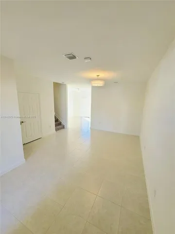 an empty room with windows and cabinet