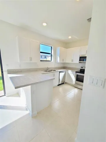 a kitchen with granite countertop cabinets and steel stainless steel appliances