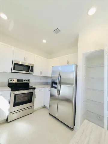 a bathroom with a double vanity sink and mirror with toilet
