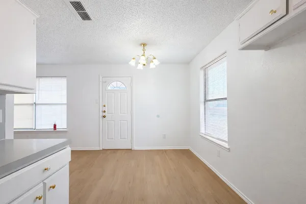 a view of a kitchen with a sink and cabinet with chandelier