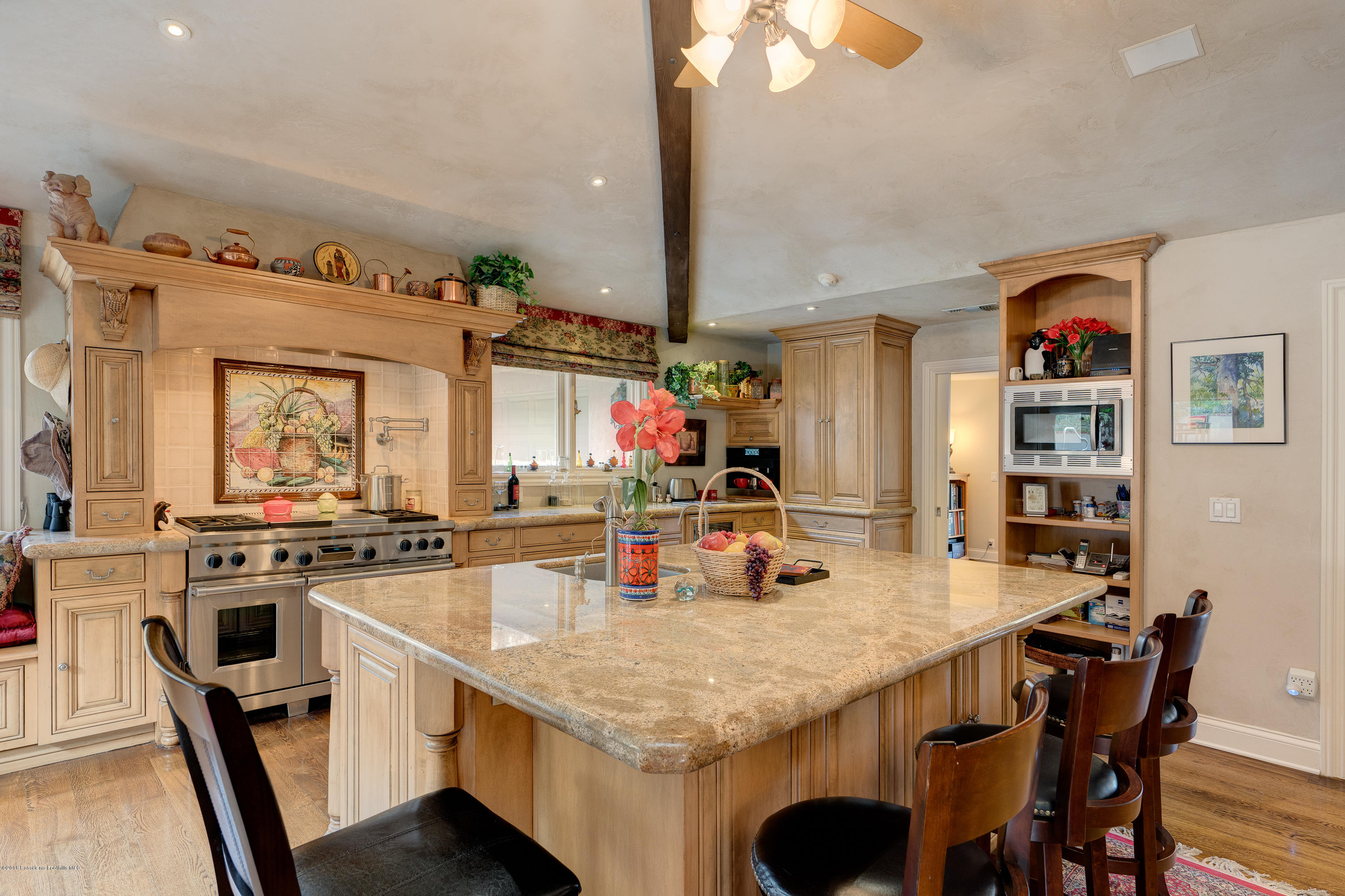 1550 Pegfair Estates Drive Pasadena, CA 91103 - Photo 9 of 16 a kitchen with stainless steel appliances granite countertop a table chairs stove and white cabinets