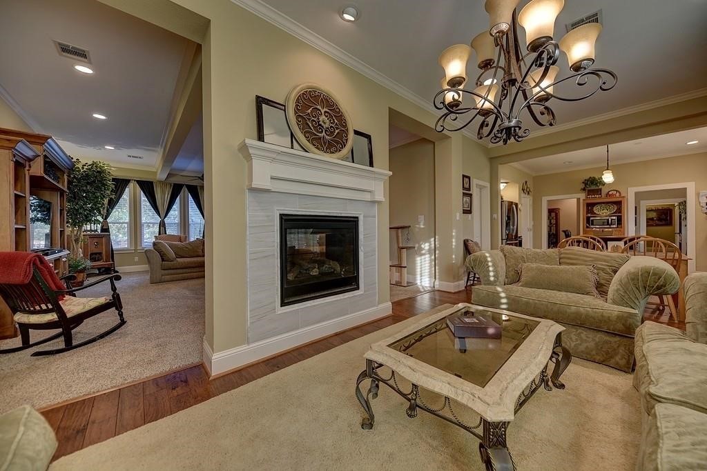 8456 Schuster Road Ledbetter, TX 78946 - Photo 16 of 49 a living room with furniture a chandelier and a fireplace