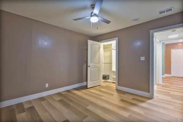 a view of empty room with wooden floor