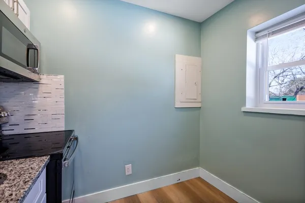 a view of room with window and wooden floor