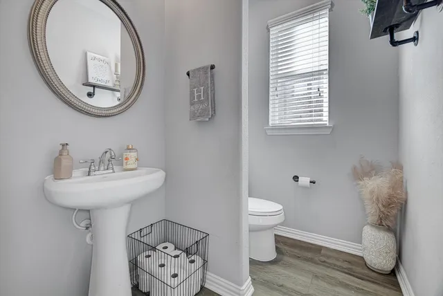a bathroom with a toilet a sink and a mirror