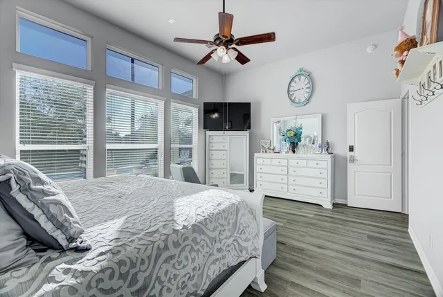 a bedroom with a bed a window and a flat screen tv