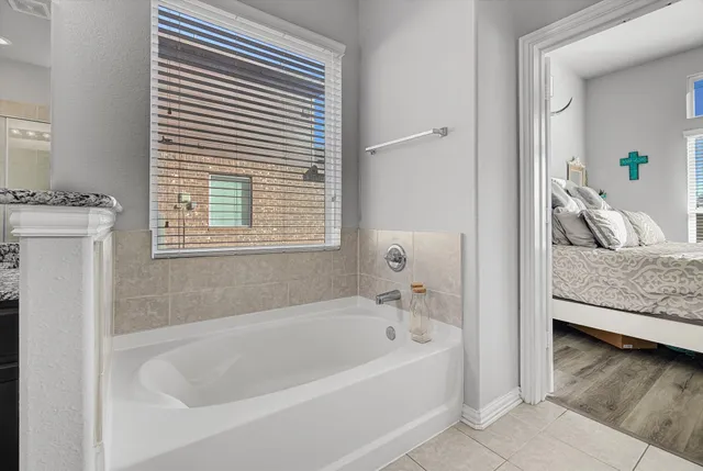 a white bath tub sitting in a bathroom next to a window
