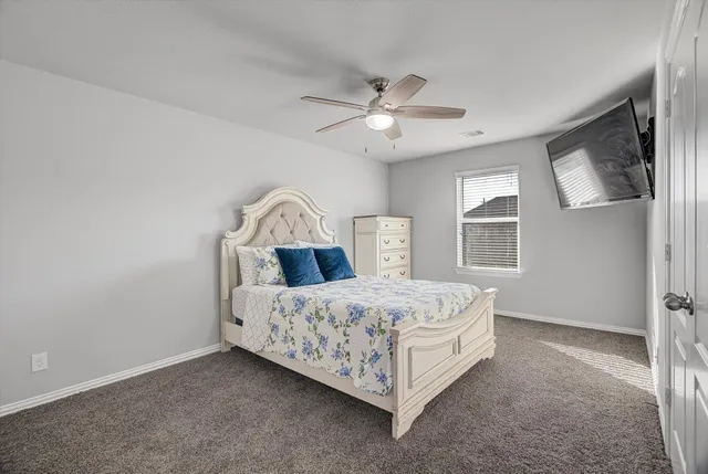 a bedroom with a bed chandelier and a window