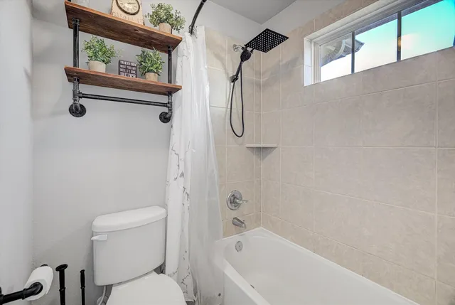 a bathroom with a toilet and shower