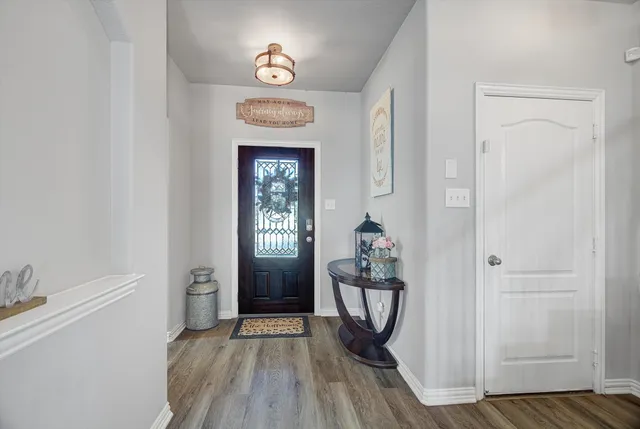 a view of a hallway and wooden floor and a window in a room