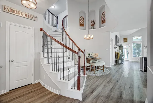 a view of a hallway with wooden floor and a dining table