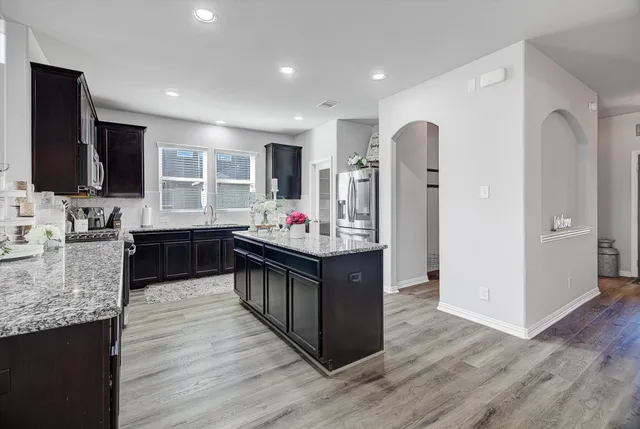 a kitchen with stainless steel appliances granite countertop a stove and a refrigerator