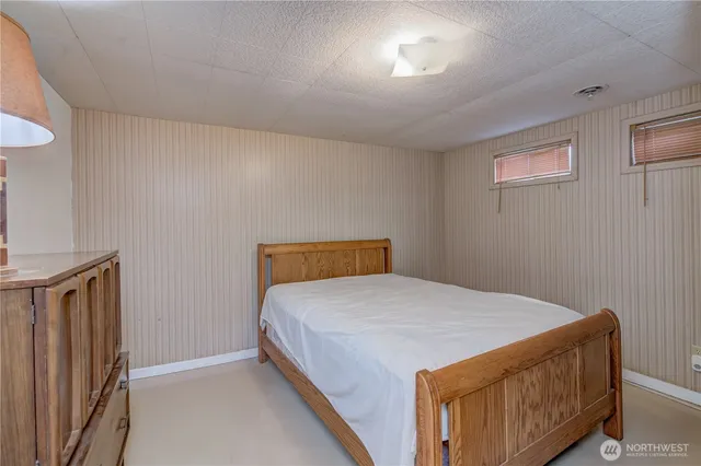 a bed sitting in a bedroom next to a window