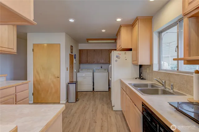 a kitchen with a sink a stove a refrigerator and a cabinets