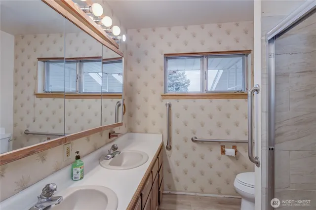 a bathroom with a granite countertop sink a toilet and a mirror