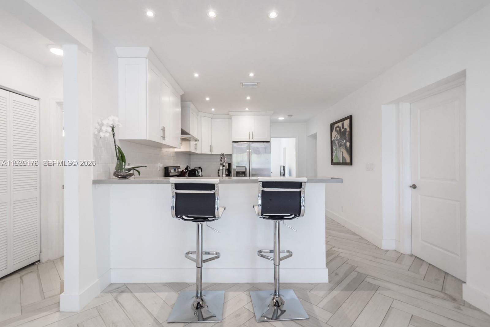 44 Northwest 40th Street Miami, FL 33127 - Photo 11 of 25 a kitchen with stainless steel appliances kitchen island sink refrigerator and cabinets