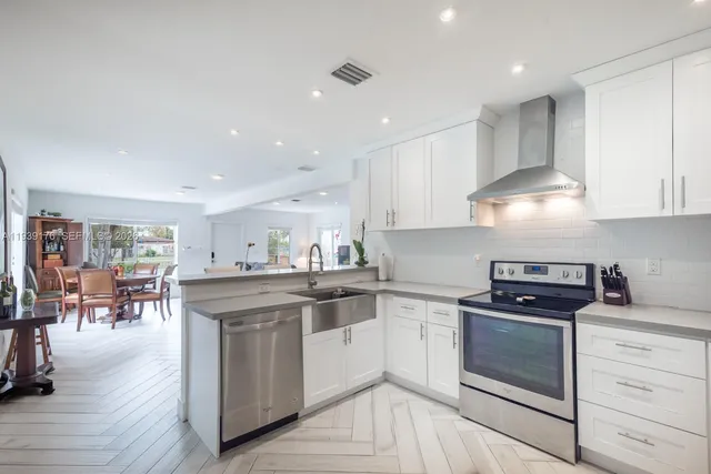 a kitchen with stainless steel appliances granite countertop a stove and white cabinets
