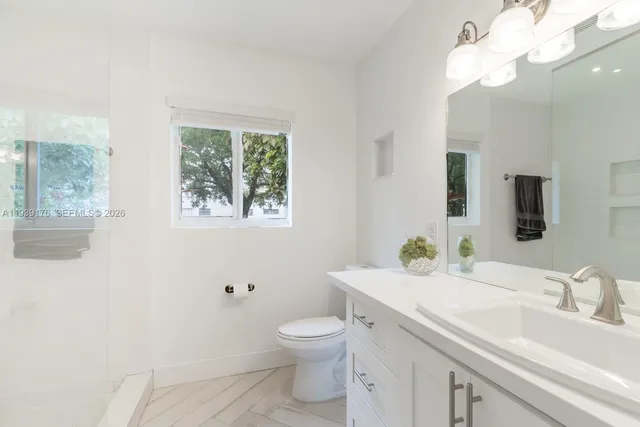 a bathroom with a toilet a sink and mirror