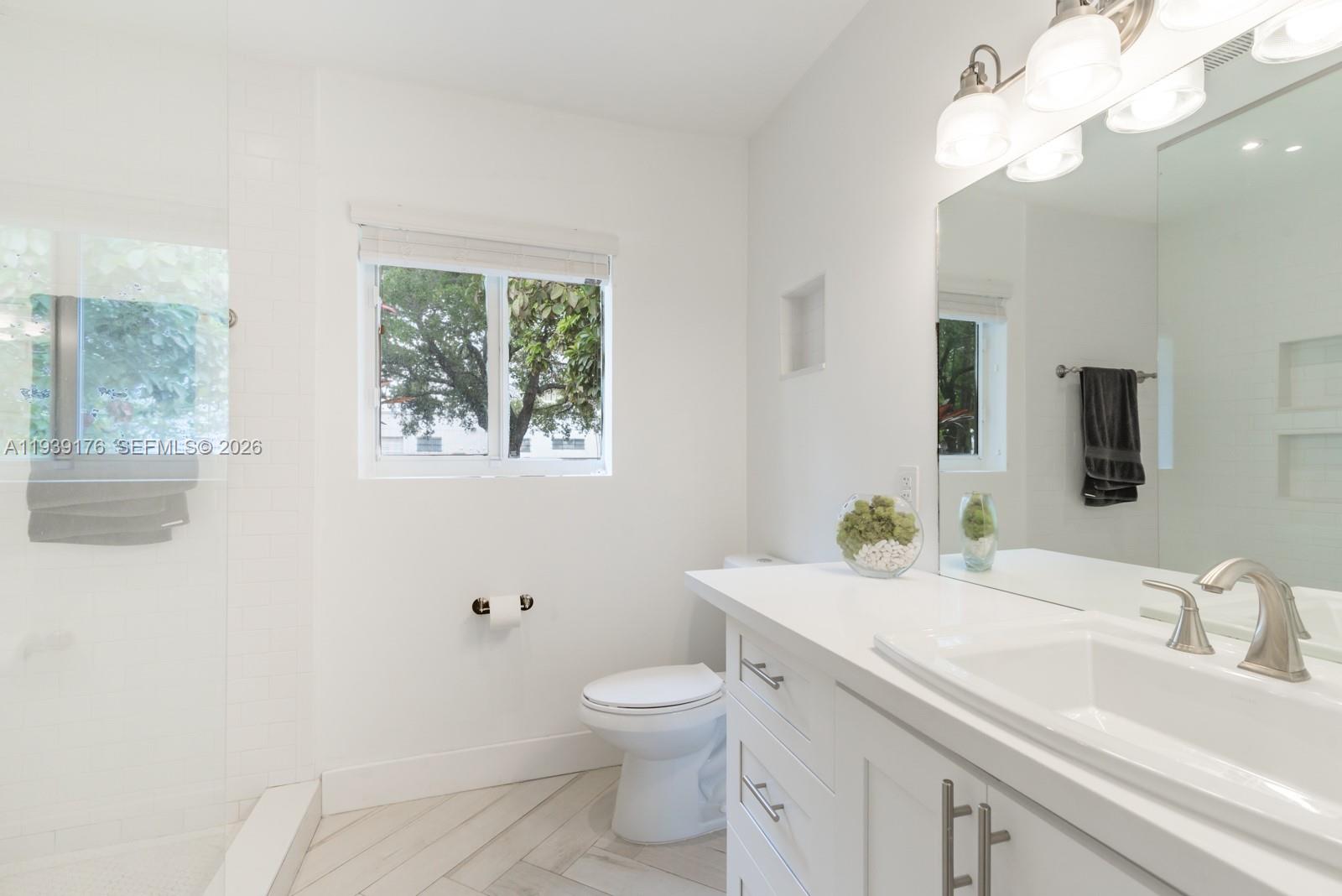 44 Northwest 40th Street Miami, FL 33127 - Photo 17 of 25 a bathroom with a toilet a sink and mirror