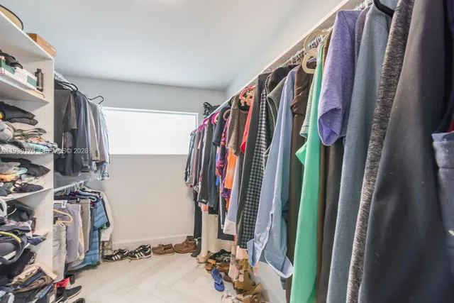 a view of walk in closet with clothes