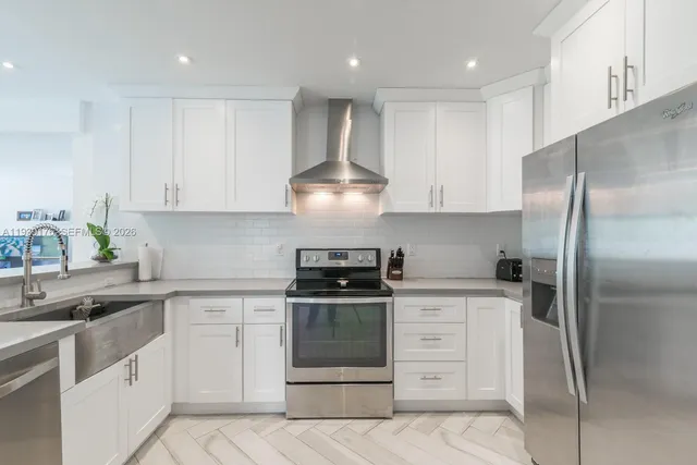 a kitchen with white cabinets and stainless steel appliances