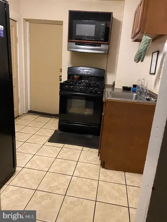 a kitchen with granite countertop a stove a microwave and a refrigerator